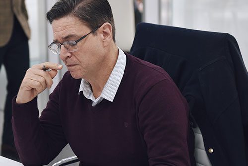 Hombre con lentes sosteniendo lápiz